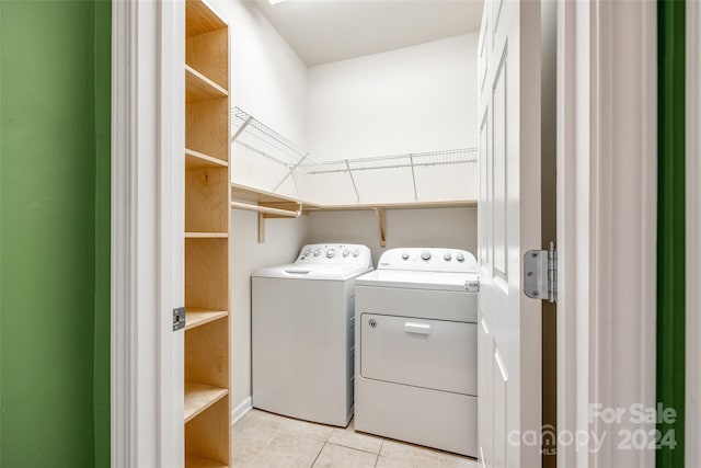 laundry area featuring washer and clothes dryer and light tile patterned floors