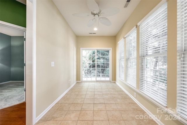 unfurnished sunroom with ceiling fan