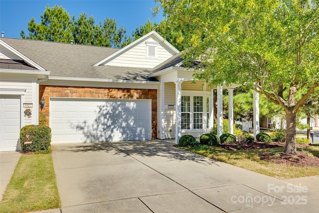 view of front facade featuring brick siding, concrete driveway, a garage, and a shingled roof