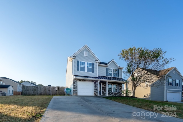 view of property featuring a garage and a front lawn