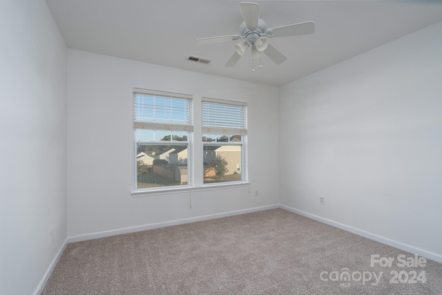 carpeted spare room with ceiling fan