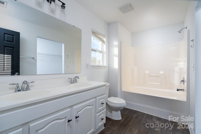 full bathroom with vanity, wood-type flooring, toilet, and shower / bath combination