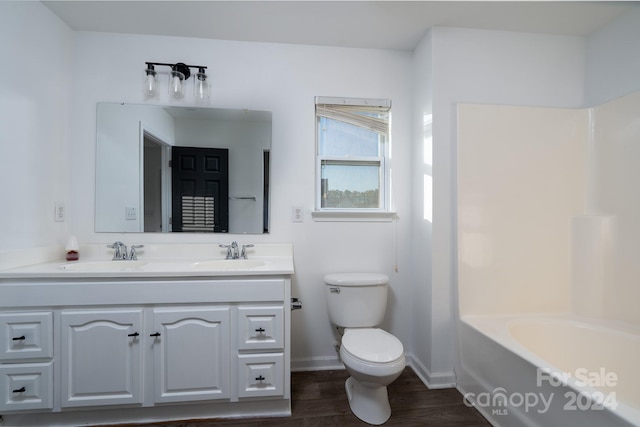 bathroom featuring vanity, toilet, a washtub, and hardwood / wood-style floors