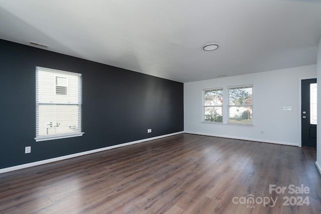 empty room with dark hardwood / wood-style flooring