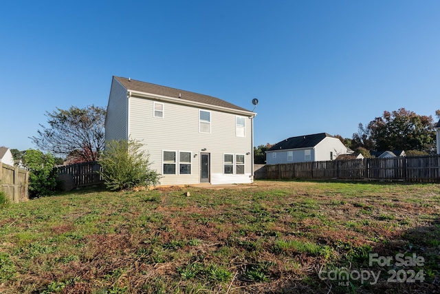 rear view of property featuring a patio and a yard