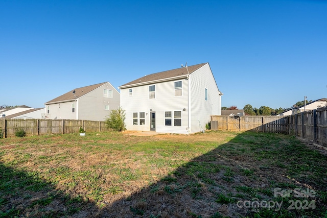 back of house with central air condition unit and a lawn