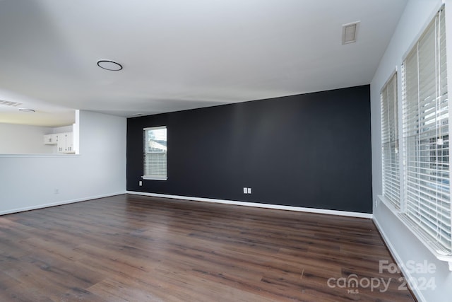 unfurnished room with dark hardwood / wood-style flooring