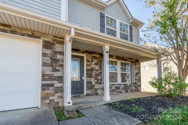 doorway to property with a porch and a garage