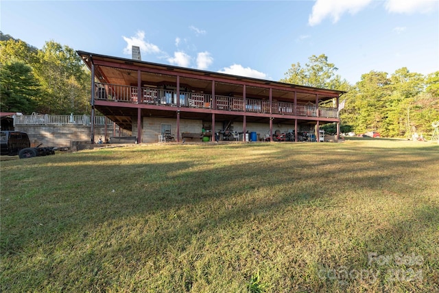 back of property featuring a wooden deck and a yard