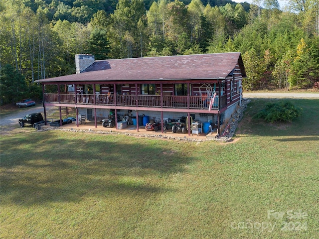 back of property with a wooden deck and a lawn