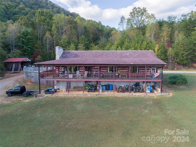 rear view of property with a wooden deck and a yard