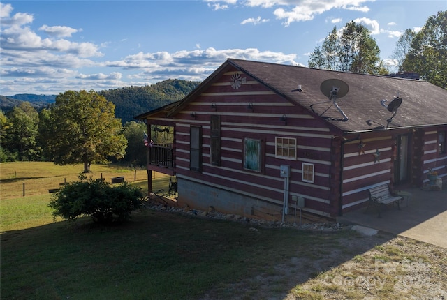 exterior space with a mountain view and a front yard