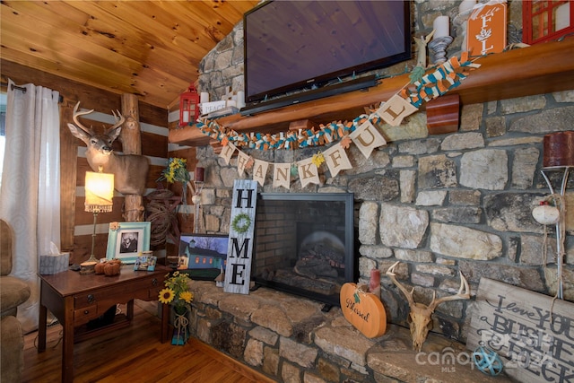 living room featuring lofted ceiling, a fireplace, hardwood / wood-style flooring, and wooden ceiling