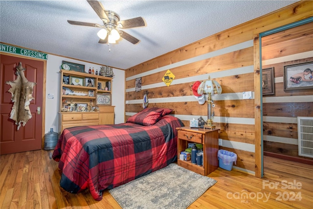 bedroom featuring a textured ceiling, light hardwood / wood-style floors, and ceiling fan