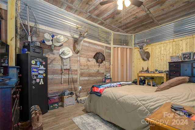 bedroom with wood ceiling, wooden walls, light wood-type flooring, and ceiling fan