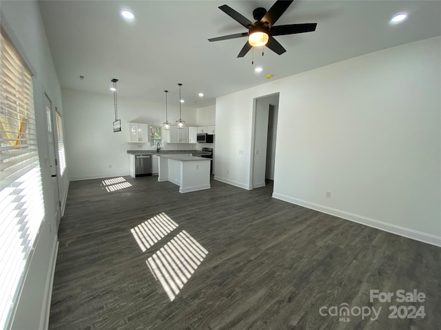 unfurnished living room featuring ceiling fan and dark hardwood / wood-style flooring