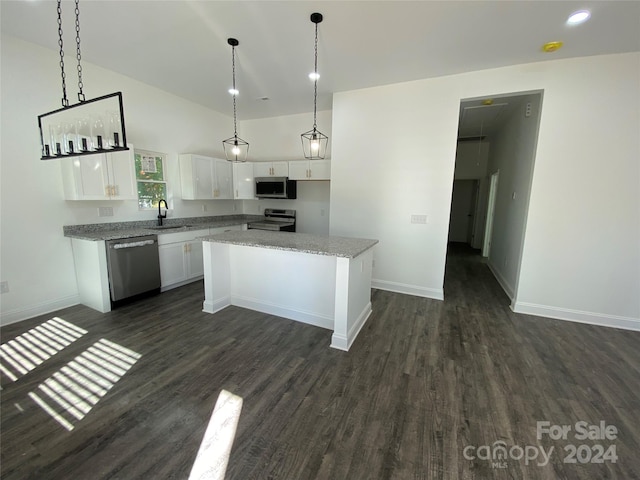 kitchen with a center island, appliances with stainless steel finishes, dark hardwood / wood-style floors, and white cabinets