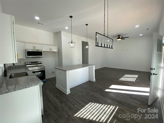 kitchen featuring a kitchen island, dark hardwood / wood-style floors, stainless steel appliances, light stone countertops, and white cabinets