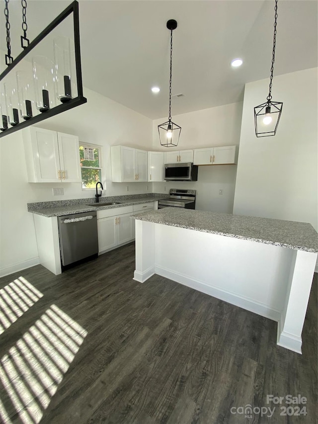 kitchen with appliances with stainless steel finishes, white cabinets, decorative light fixtures, and sink