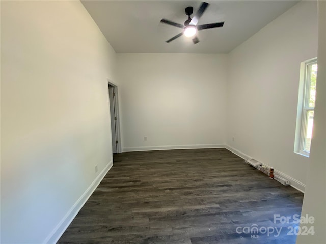 empty room with dark wood-type flooring and ceiling fan