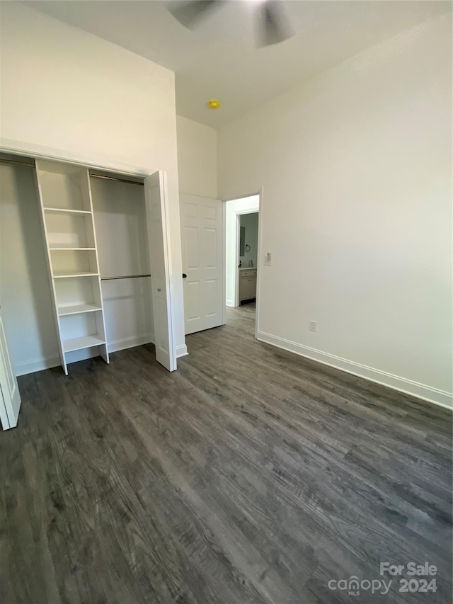 unfurnished bedroom featuring a closet, dark hardwood / wood-style floors, and ceiling fan