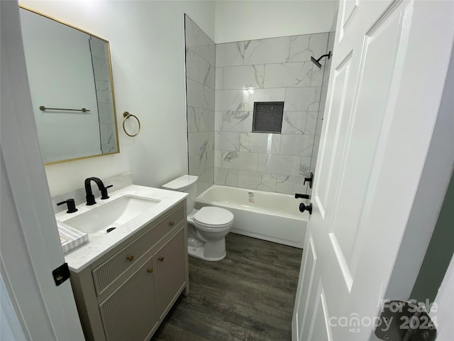 full bathroom with vanity, toilet, hardwood / wood-style flooring, and tiled shower / bath combo