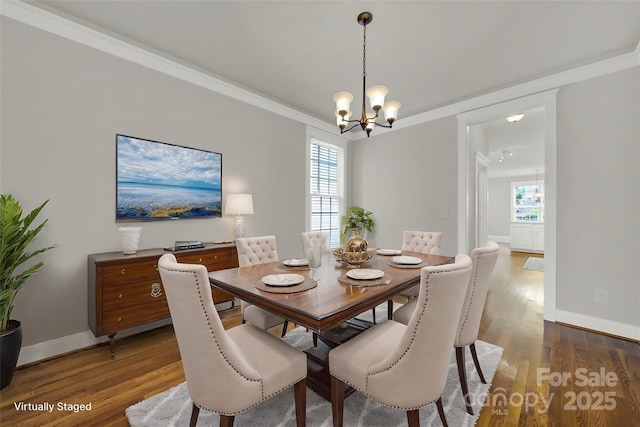 dining space featuring crown molding, dark hardwood / wood-style flooring, and a chandelier