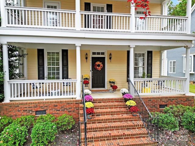 property entrance featuring a balcony and covered porch