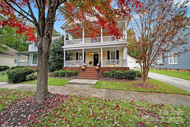 view of front of home featuring a porch, a balcony, and a garage