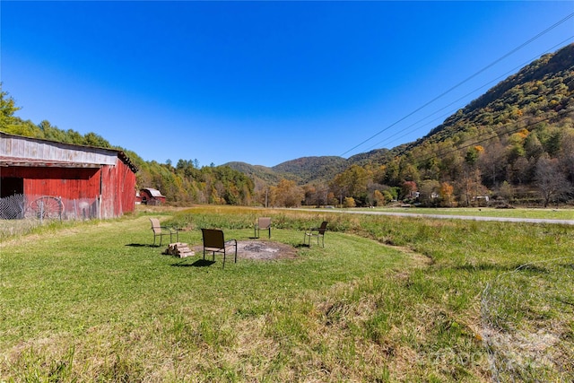 view of yard featuring a mountain view, a rural view, and an outdoor structure