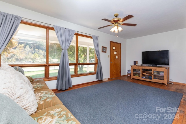 living room with ceiling fan and dark hardwood / wood-style flooring