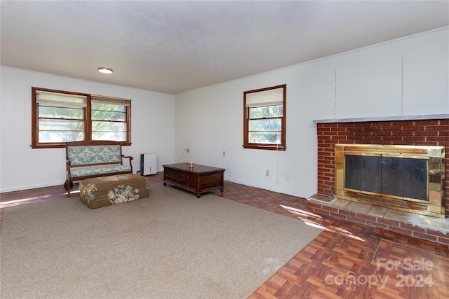 sitting room with dark parquet floors, a textured ceiling, and a brick fireplace