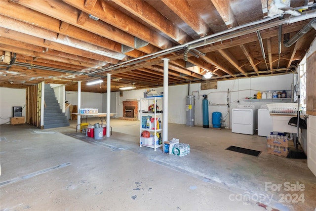 basement with electric water heater and washer and dryer