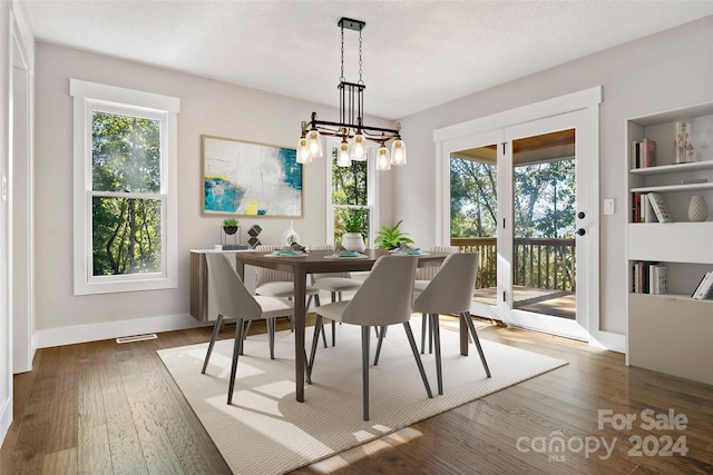 dining space with a textured ceiling, a chandelier, and dark hardwood / wood-style flooring