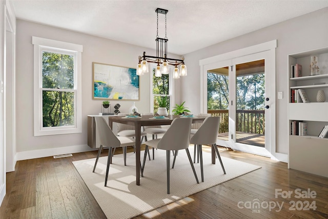 dining area with baseboards, a chandelier, and wood finished floors