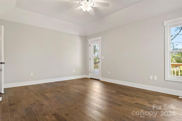 spare room with dark wood finished floors, baseboards, and a ceiling fan
