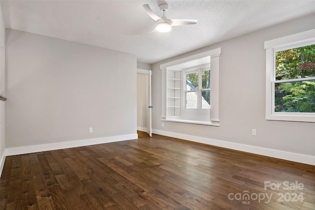 spare room with a textured ceiling, dark wood-type flooring, and ceiling fan