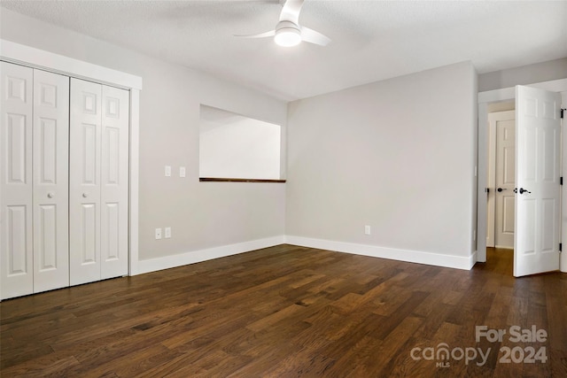 unfurnished bedroom featuring dark hardwood / wood-style flooring, a closet, a textured ceiling, and ceiling fan