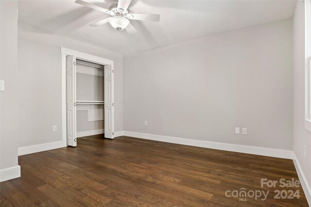 unfurnished bedroom with baseboards, a closet, ceiling fan, and dark wood-style flooring