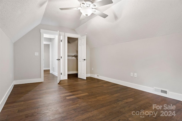 bonus room featuring lofted ceiling, a textured ceiling, dark hardwood / wood-style floors, and ceiling fan