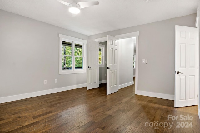 unfurnished bedroom with ceiling fan and dark hardwood / wood-style flooring