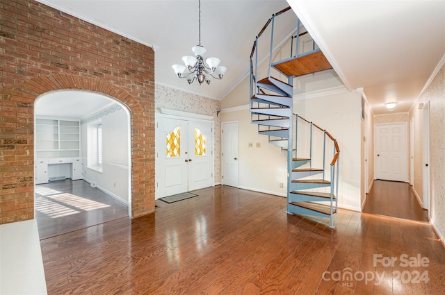 entrance foyer featuring crown molding, dark hardwood / wood-style floors, high vaulted ceiling, and a notable chandelier