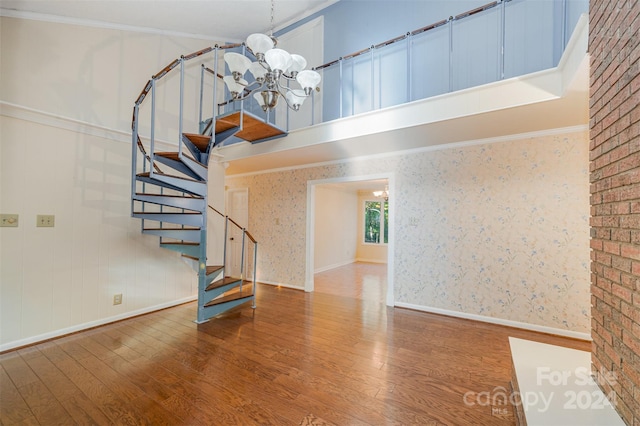 stairs featuring crown molding, a chandelier, and hardwood / wood-style floors