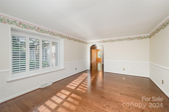 unfurnished room with ornamental molding and hardwood / wood-style floors