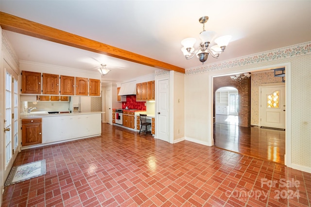 kitchen with an inviting chandelier, ornamental molding, hanging light fixtures, and plenty of natural light