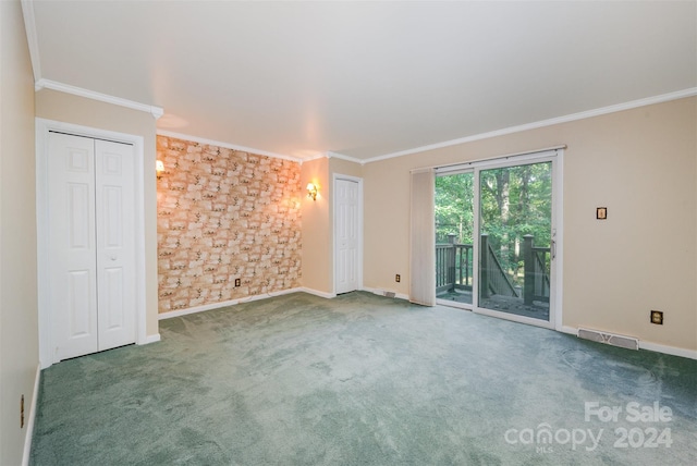 carpeted spare room featuring crown molding