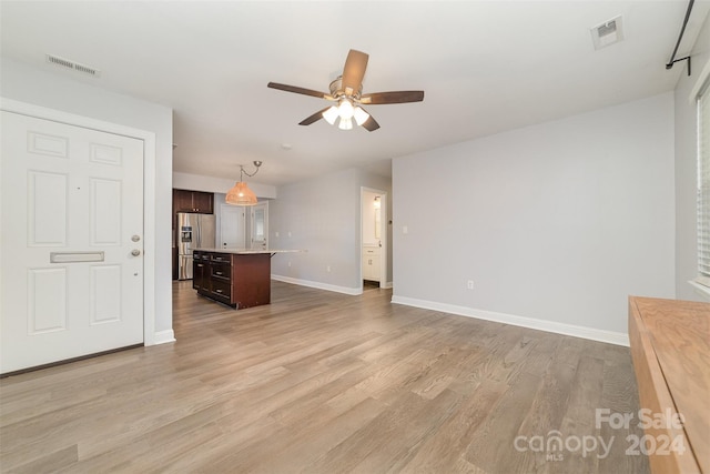 unfurnished living room featuring light hardwood / wood-style flooring and ceiling fan