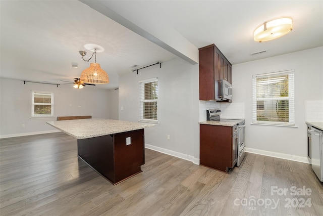 kitchen with a healthy amount of sunlight, appliances with stainless steel finishes, and tasteful backsplash