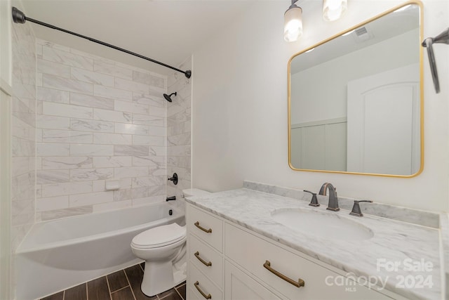 full bathroom featuring vanity, tiled shower / bath combo, and toilet