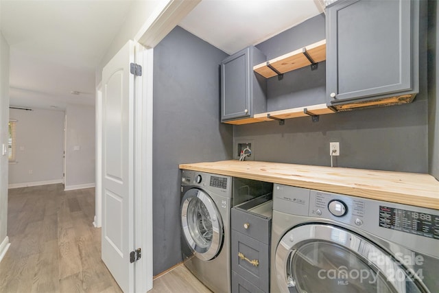 laundry area featuring light hardwood / wood-style floors, cabinets, and independent washer and dryer